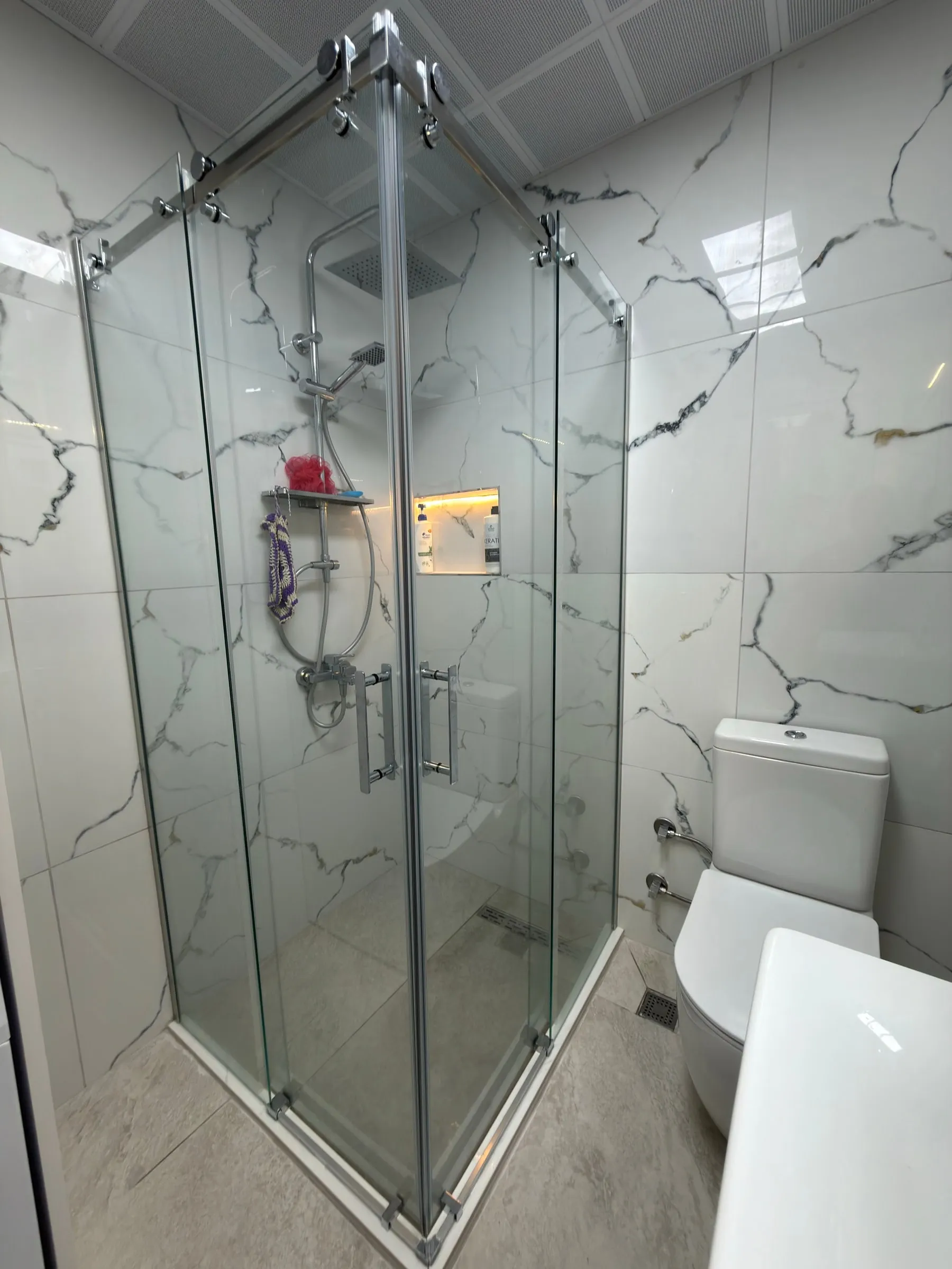 Beyaz mermer görünümlü seramik kaplı banyo ve duşakabin